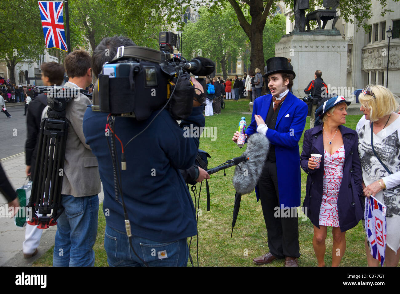 Ein Besucher nach London für die königliche Hochzeit, interviewt von Fernsehteam in Parliament Square Stockfoto