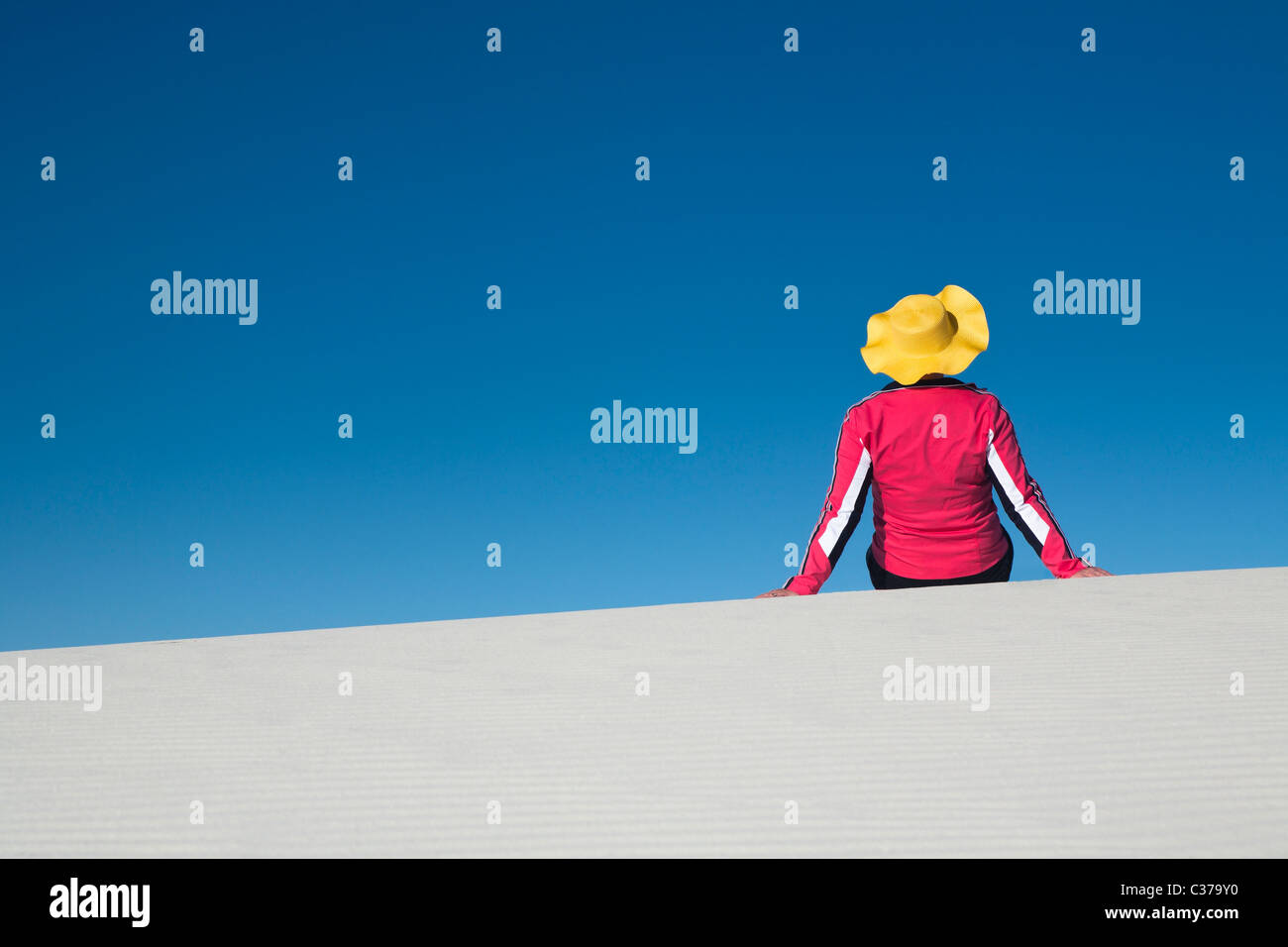 Frau, gelben Mütze, rosa Hemd, allein, weiße Sanddüne, blauer Himmel, konzeptionelle, Modell veröffentlicht Stockfoto