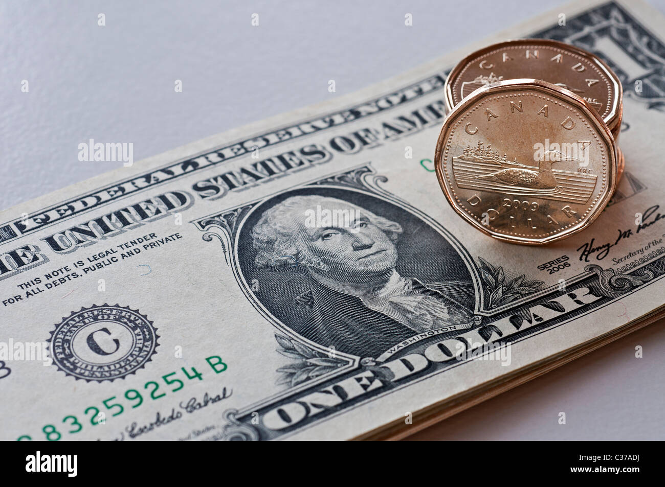 Geld; US $1-Dollarnoten und kanadische $1 Dollar Münzen (Spinner). Stockfoto