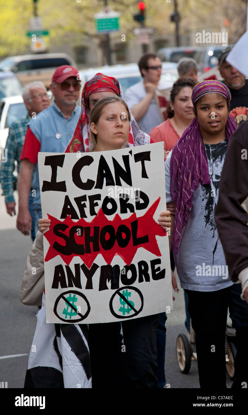 Lansing, Michigan - eine Frau hält ein Schild mit der Aufschrift, dass sie sich nicht leisten kann, weiterhin zur Schule gehen. Stockfoto