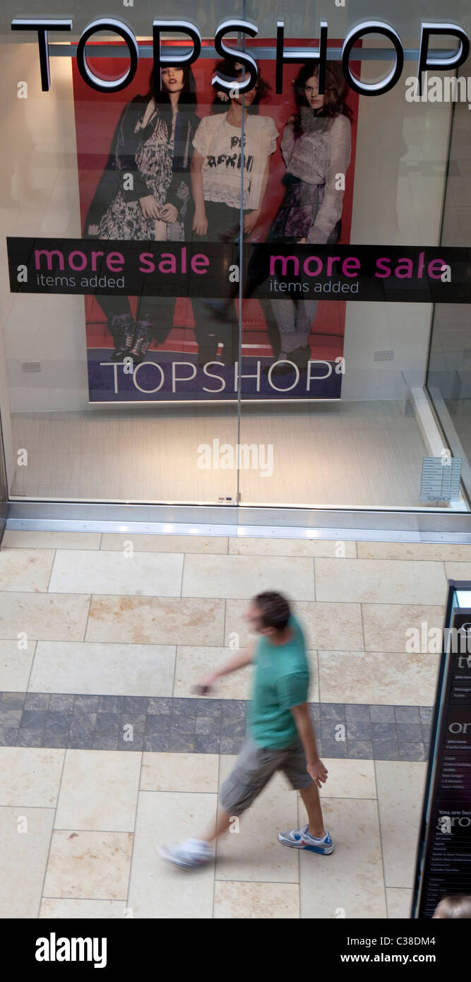 Eine Person geht vor ein Zweig der Topshop/Topman, Cambridge. Bestandteil der Gruppe "Arcadia" Stockfoto