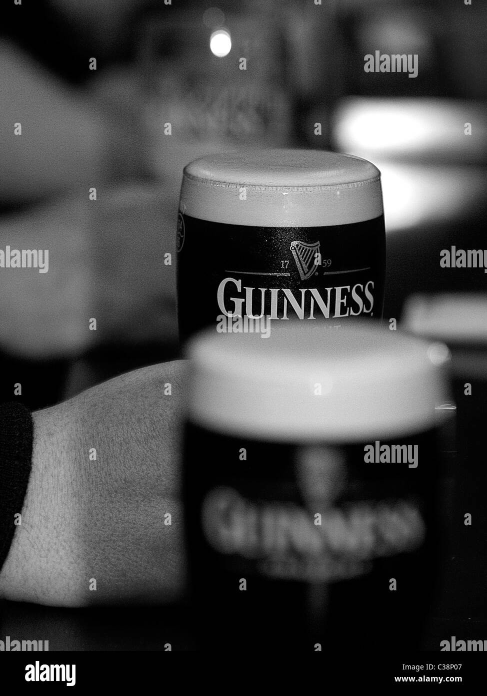 Kunden genießen Guinness in Tully es Hotelbar, Castlerea, County Roscommon, Irland. Stockfoto