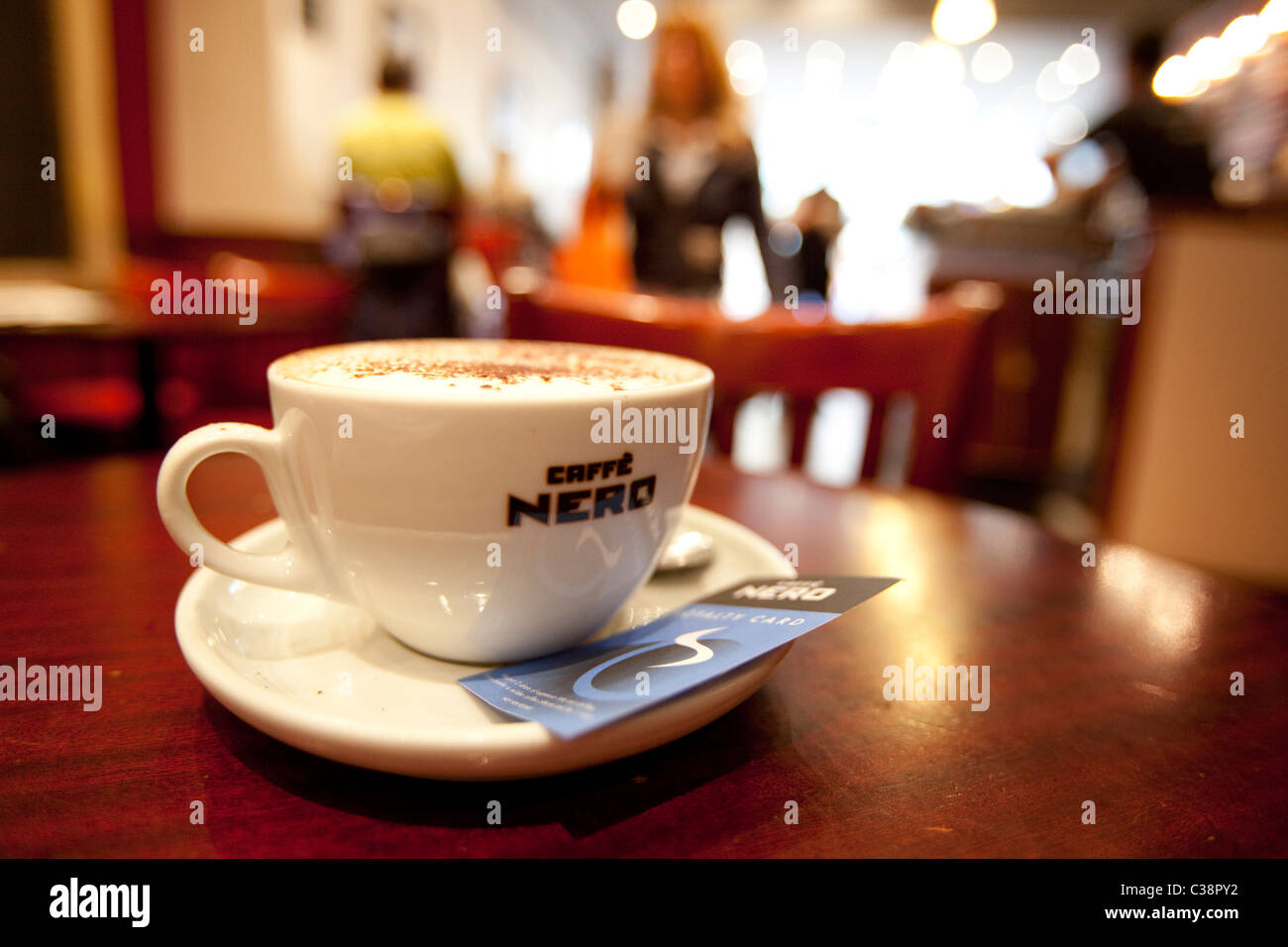 Das Innere eines Caffe Nero-Shop. Auch abgebildet sind, ein Cappuccino und Treue-Karte Stockfoto