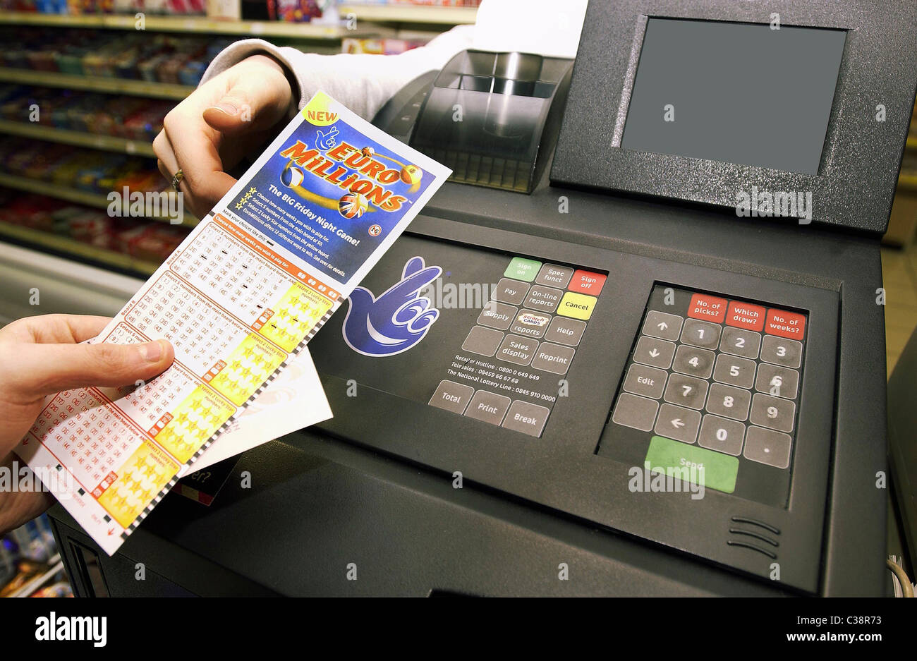 Bild zeigt: ein Euro Millions-Spielschein und eine Lotterie-Maschine. Stockfoto