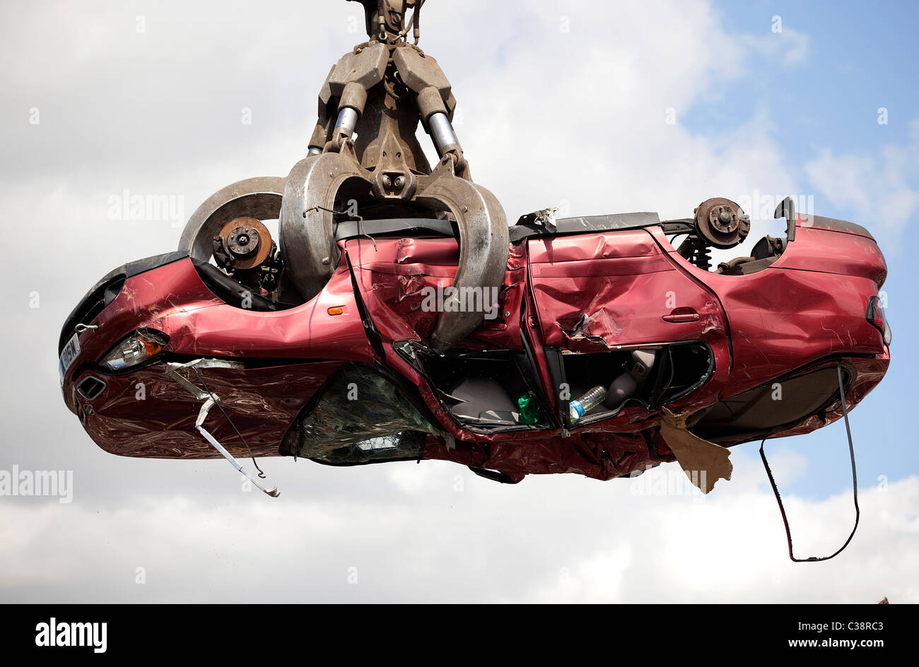 Nissan Auto wird mit einem Kran in ein anschauliches Bild von einem Schrottplatz abgeholt. Stockfoto