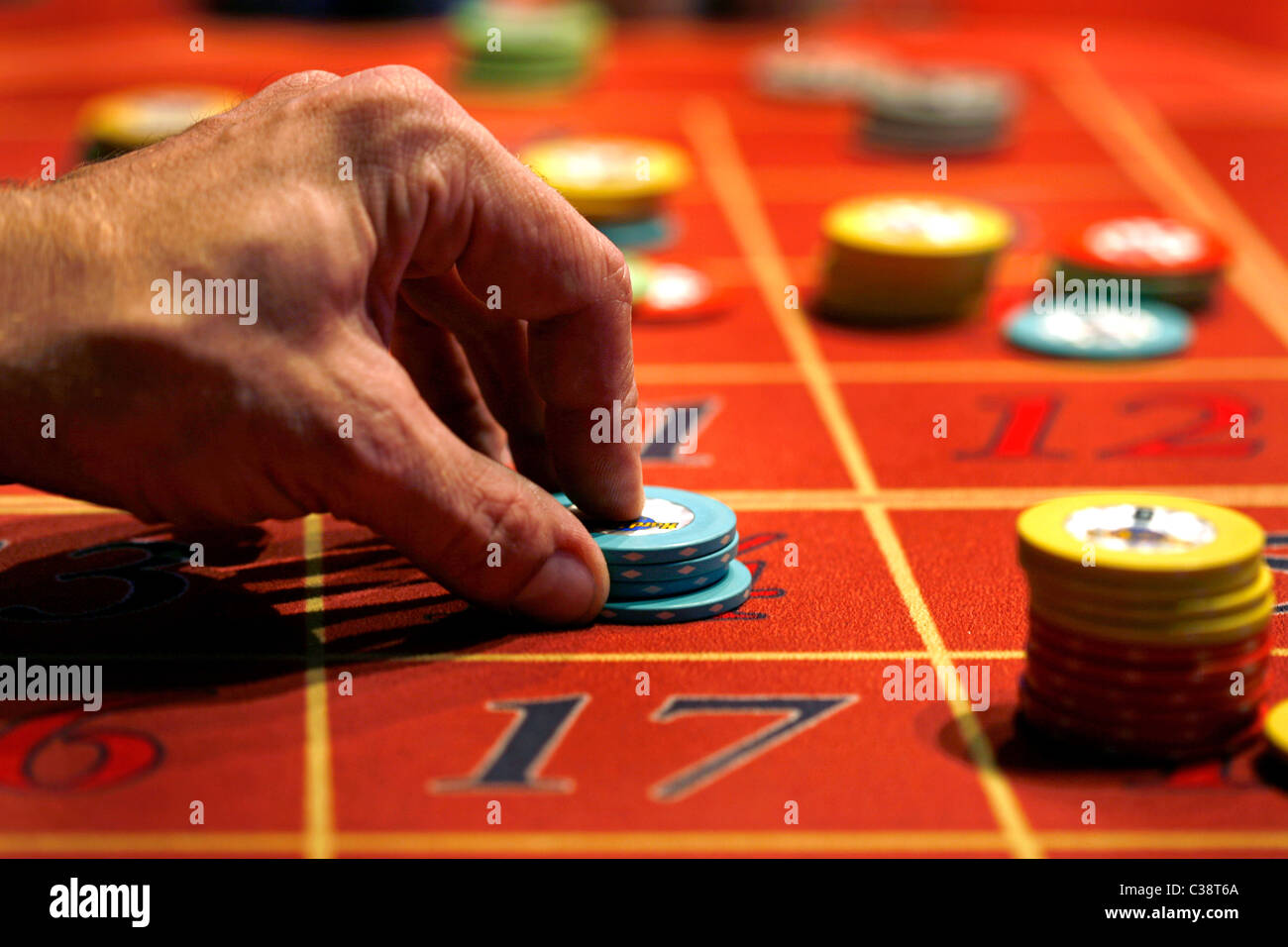 Ein Mann setzt eine Wette auf einem Roulette-Tisch Stockfoto