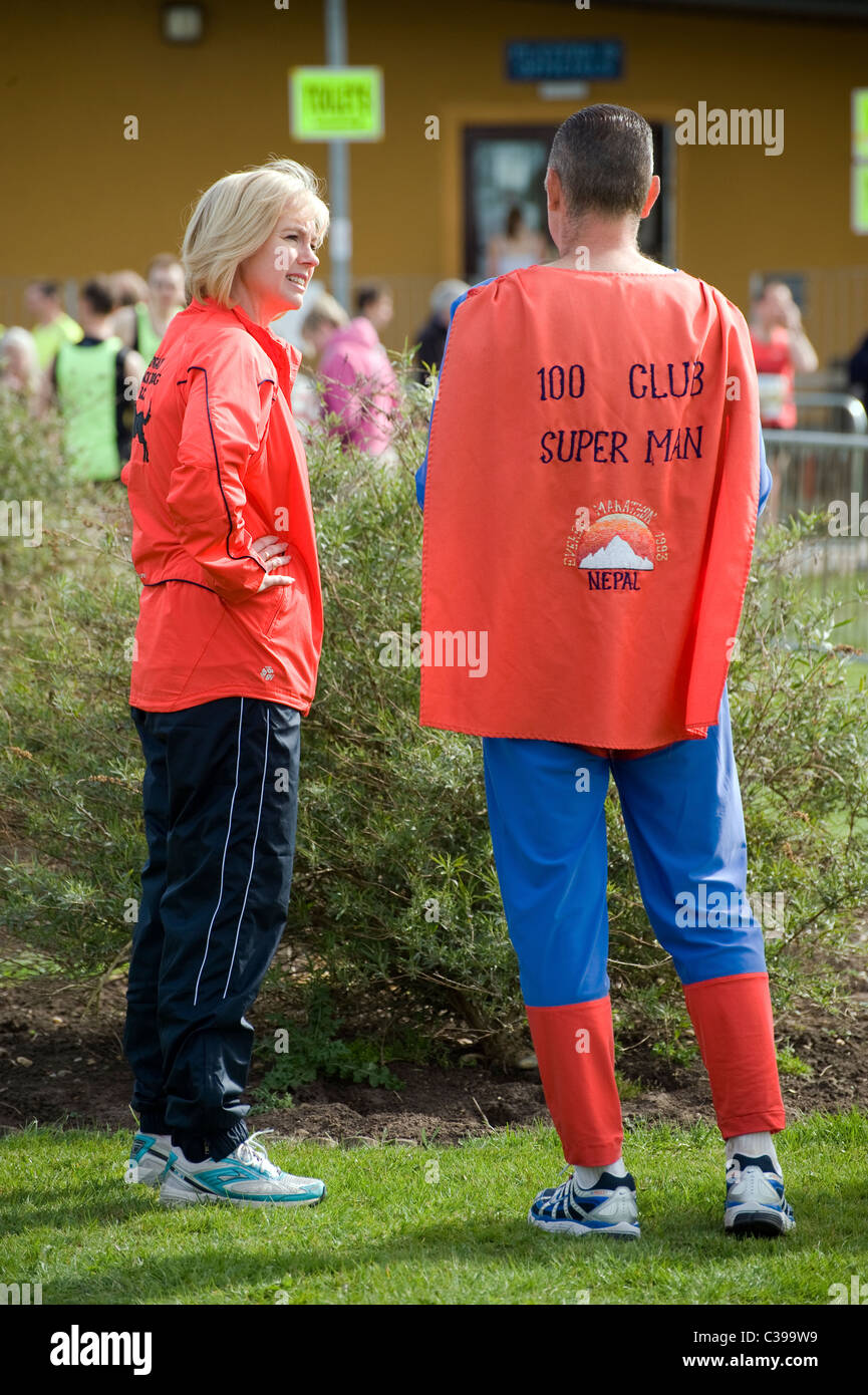 Frau im Gespräch mit Mann verkleidet als superman Stockfoto
