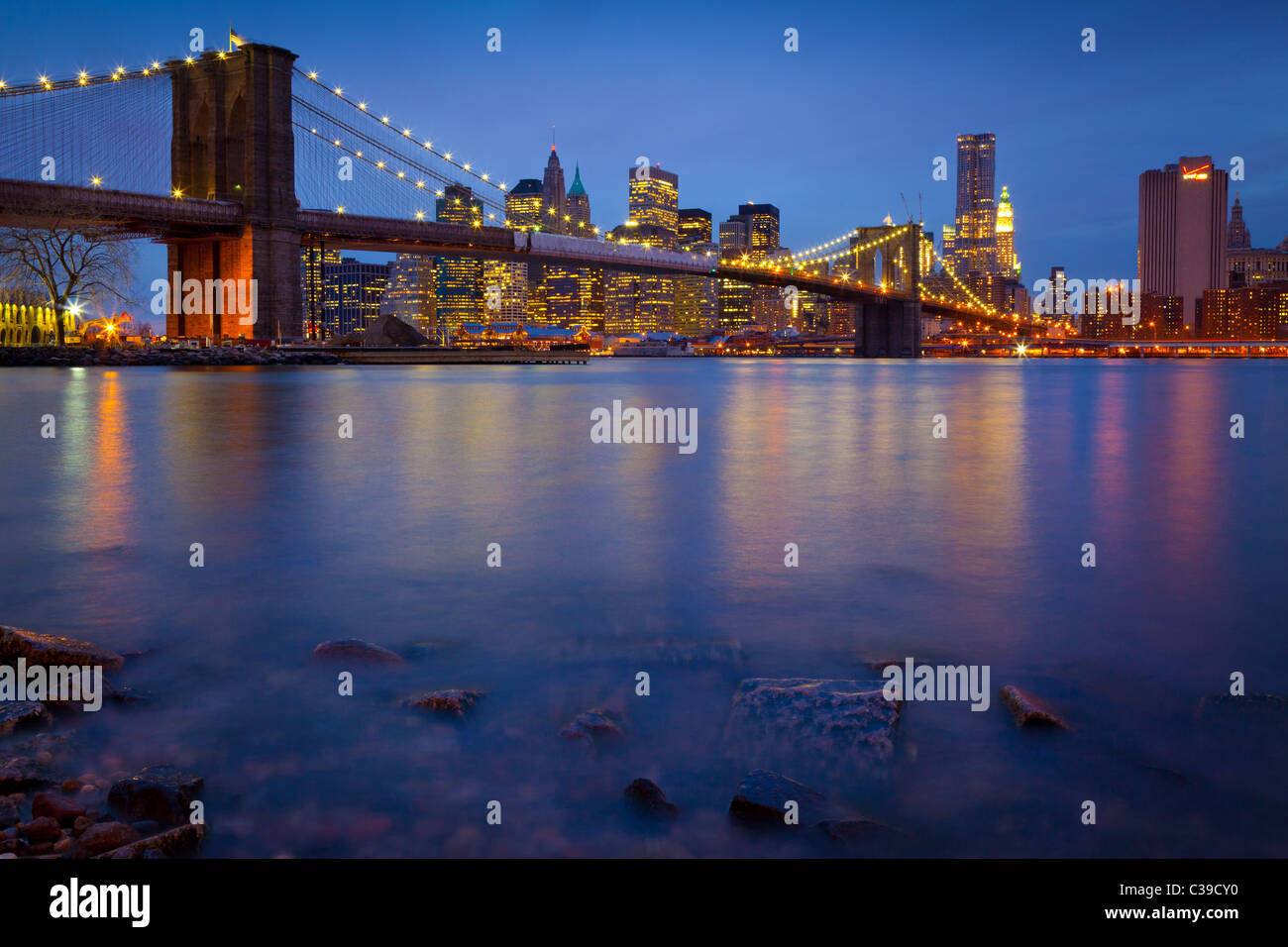 New Yorker Brooklyn Bridge, die den East River zwischen Manhattan und Brooklyn kreuzt, ist hier in der Nacht gesehen. Stockfoto