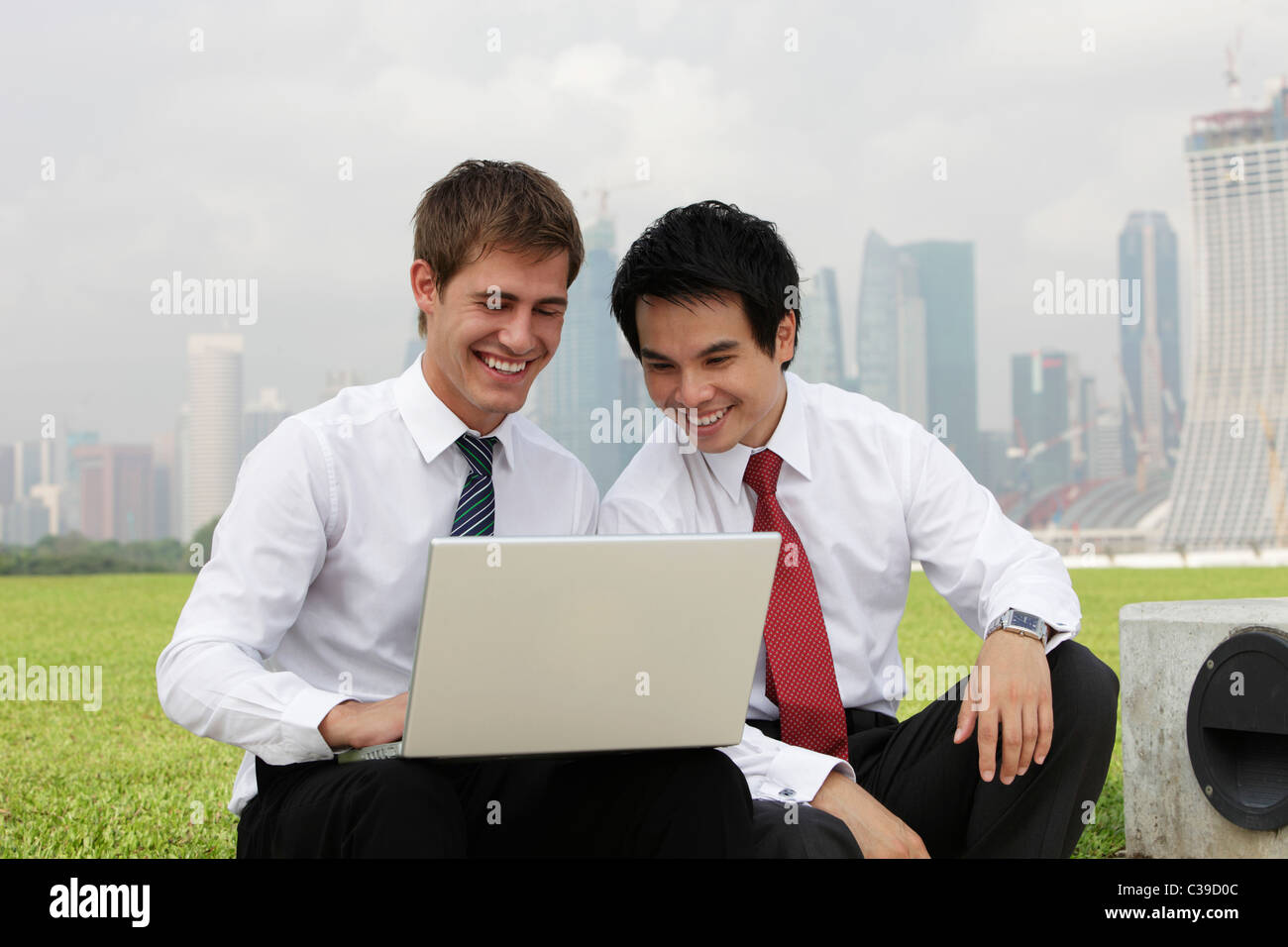 Chinesisch und kaukasischen Mann Blick auf Laptop drausen Stockfoto