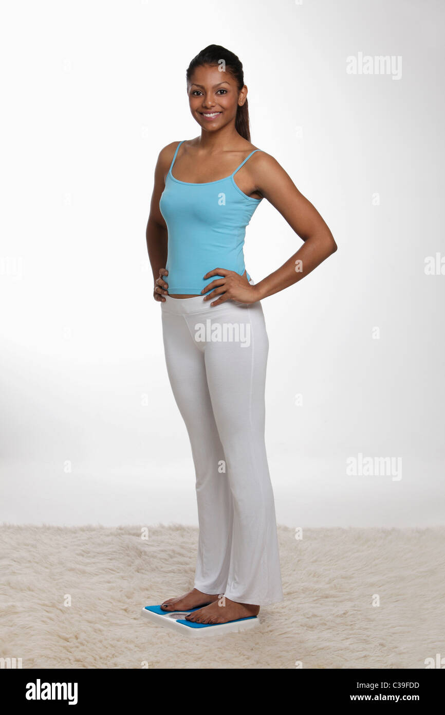 Frau stehend auf Skala mit den Händen auf den Hüften Stockfoto