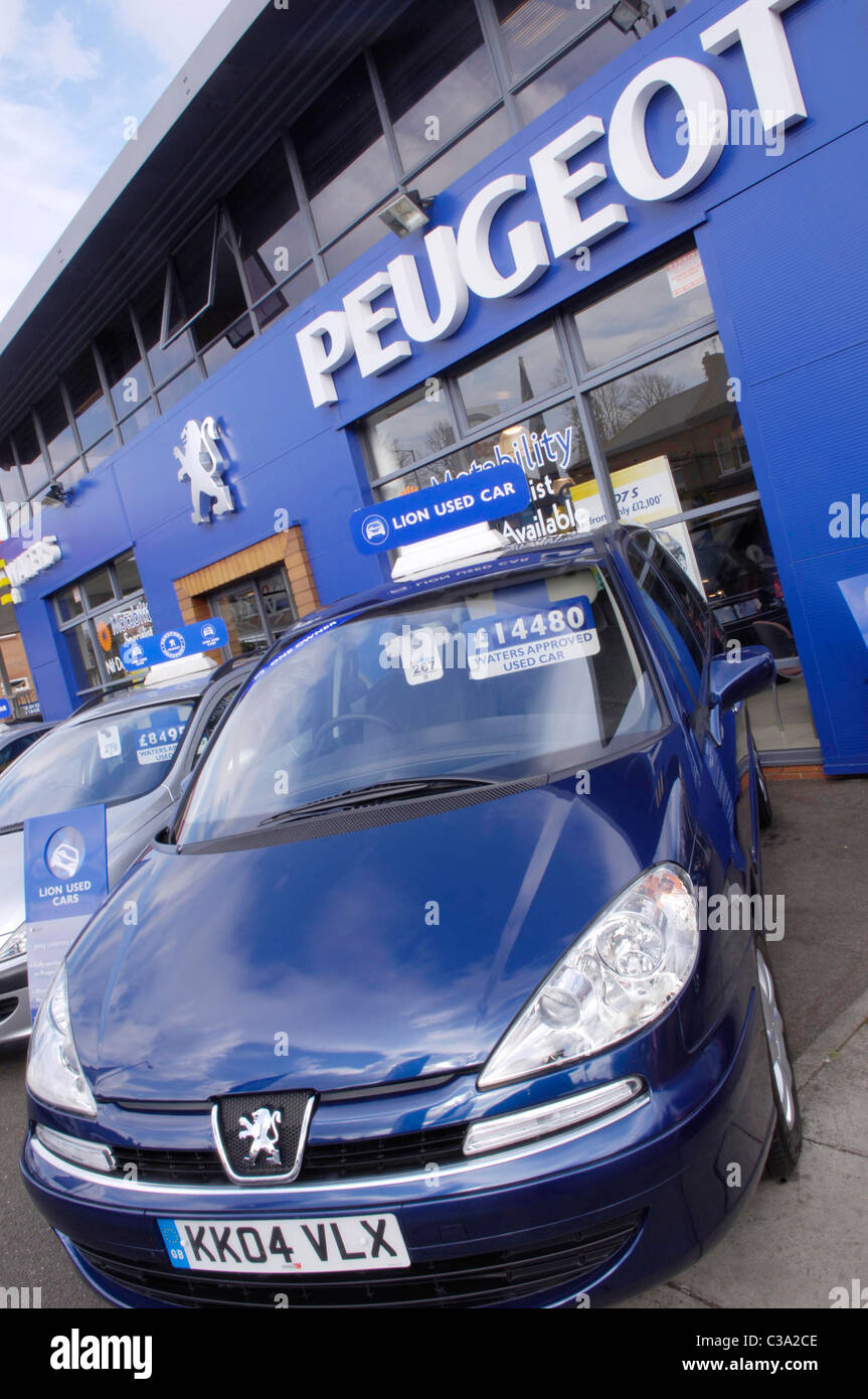 Gebrauchte Autos auf dem Display außerhalb eines Peugeot-Autohauses. Stockfoto