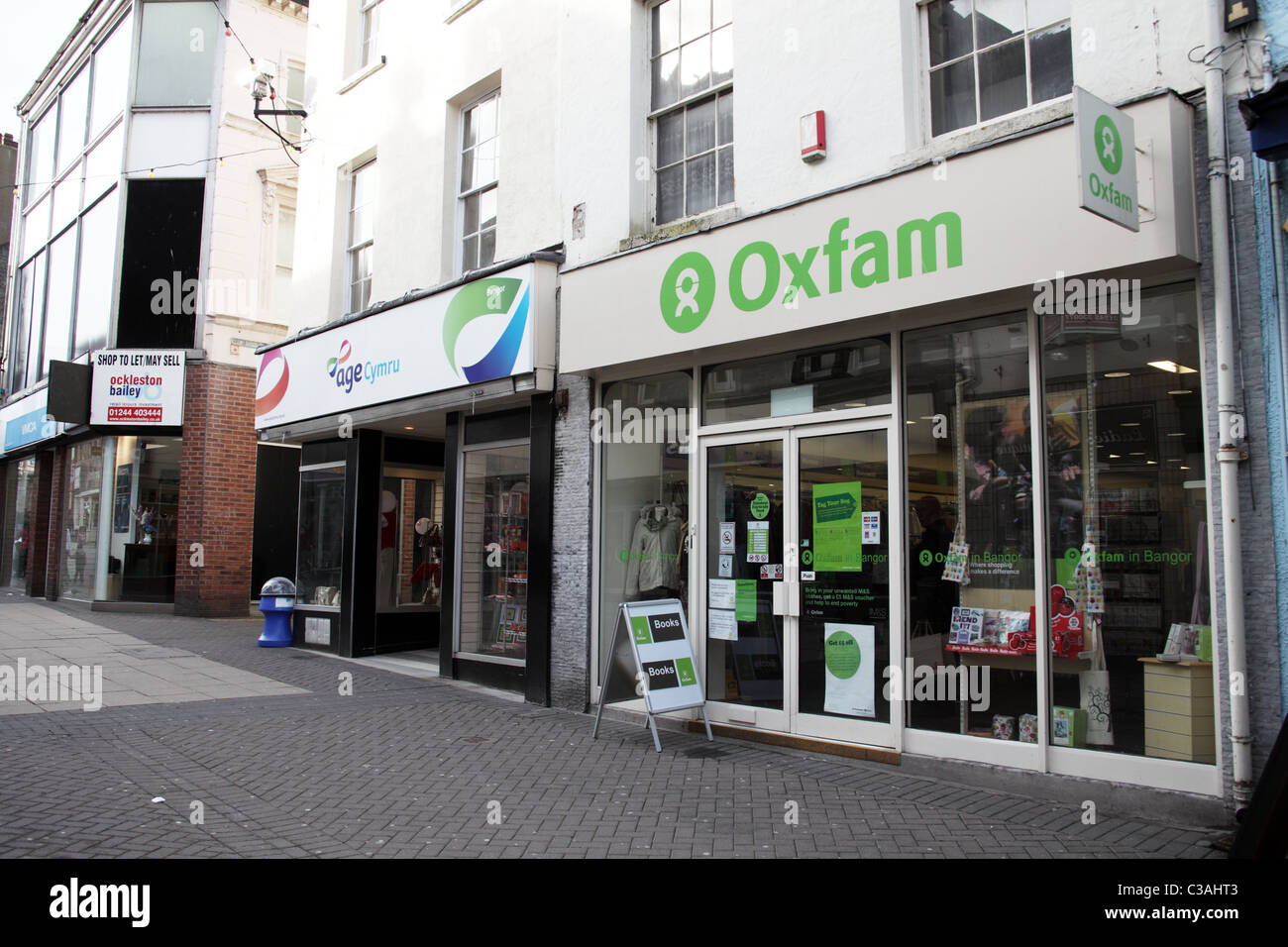 Angrenzenden Charity-Shops, Alter Cymru und Oxfam, Hautpstraße Bangor, Wales Stockfoto