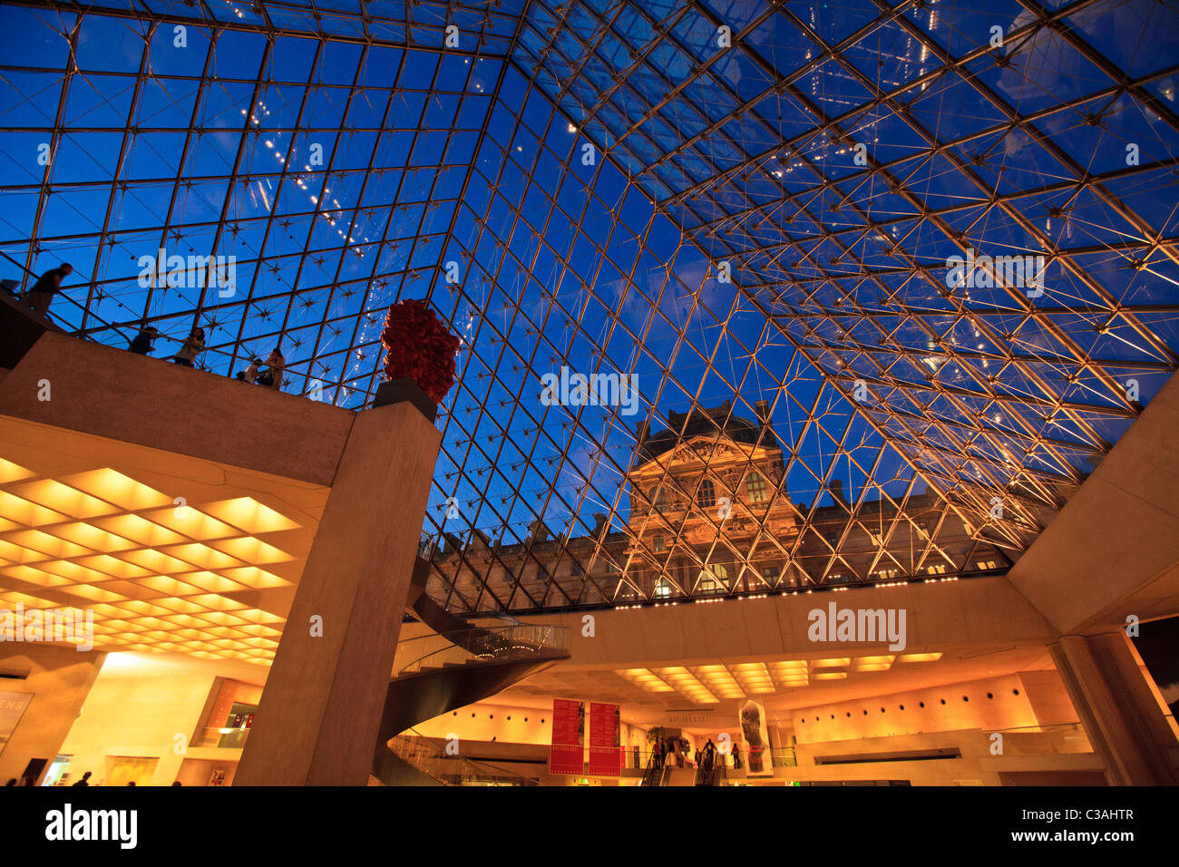 Blick durch die Glaspyramide auf den Louvre-Palast von der Museumsbahn bei Nacht, Paris Stockfoto