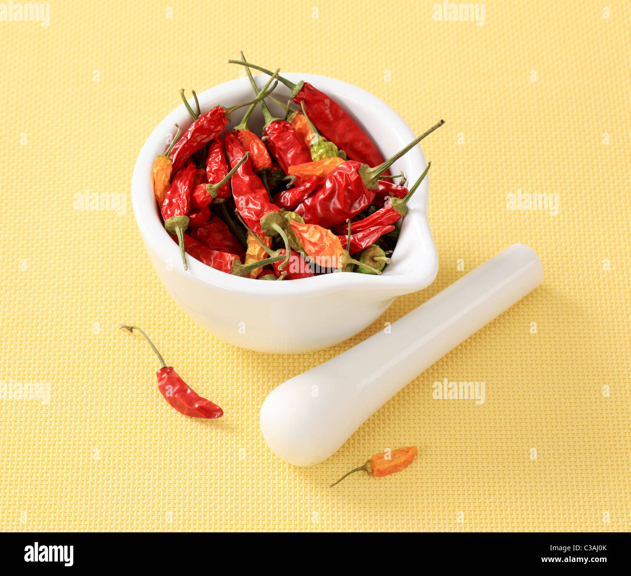 Getrocknete Chilischoten in einem Keramik Mörser Stockfoto