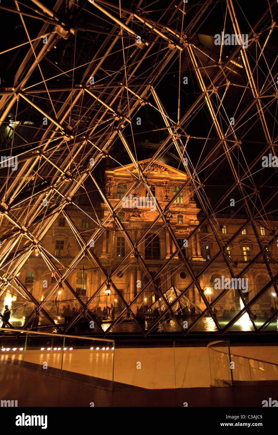 Der Louvre-Palast und der Gang aus dem Inneren der Glaspyramide des Museums bei Nacht, Paris Stockfoto