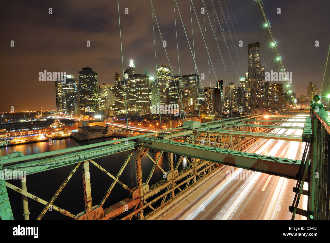 Blick auf Downtown Manhattan von der Brooklyn Bridge mit dem Verkehr von fliegen. Stockfoto