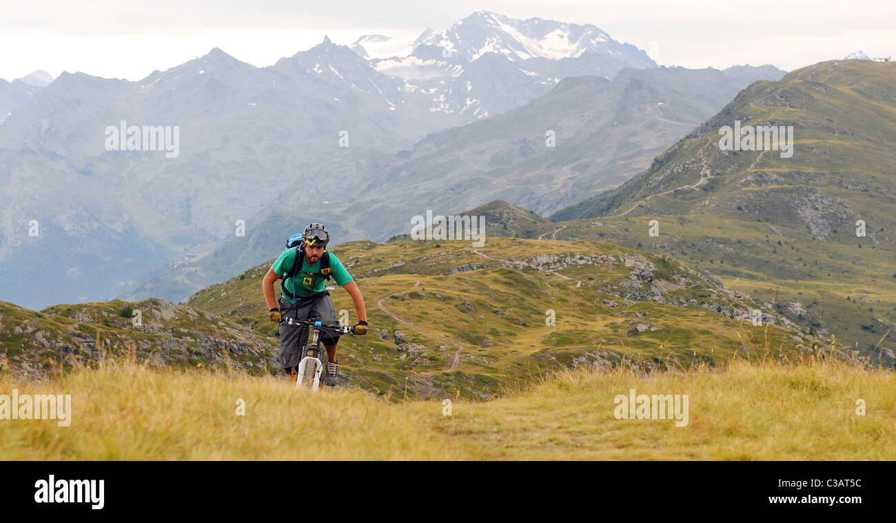 Ein Mountainbiker kämpft bergauf in Höhe in der französischen Skiort Meribel Stockfoto