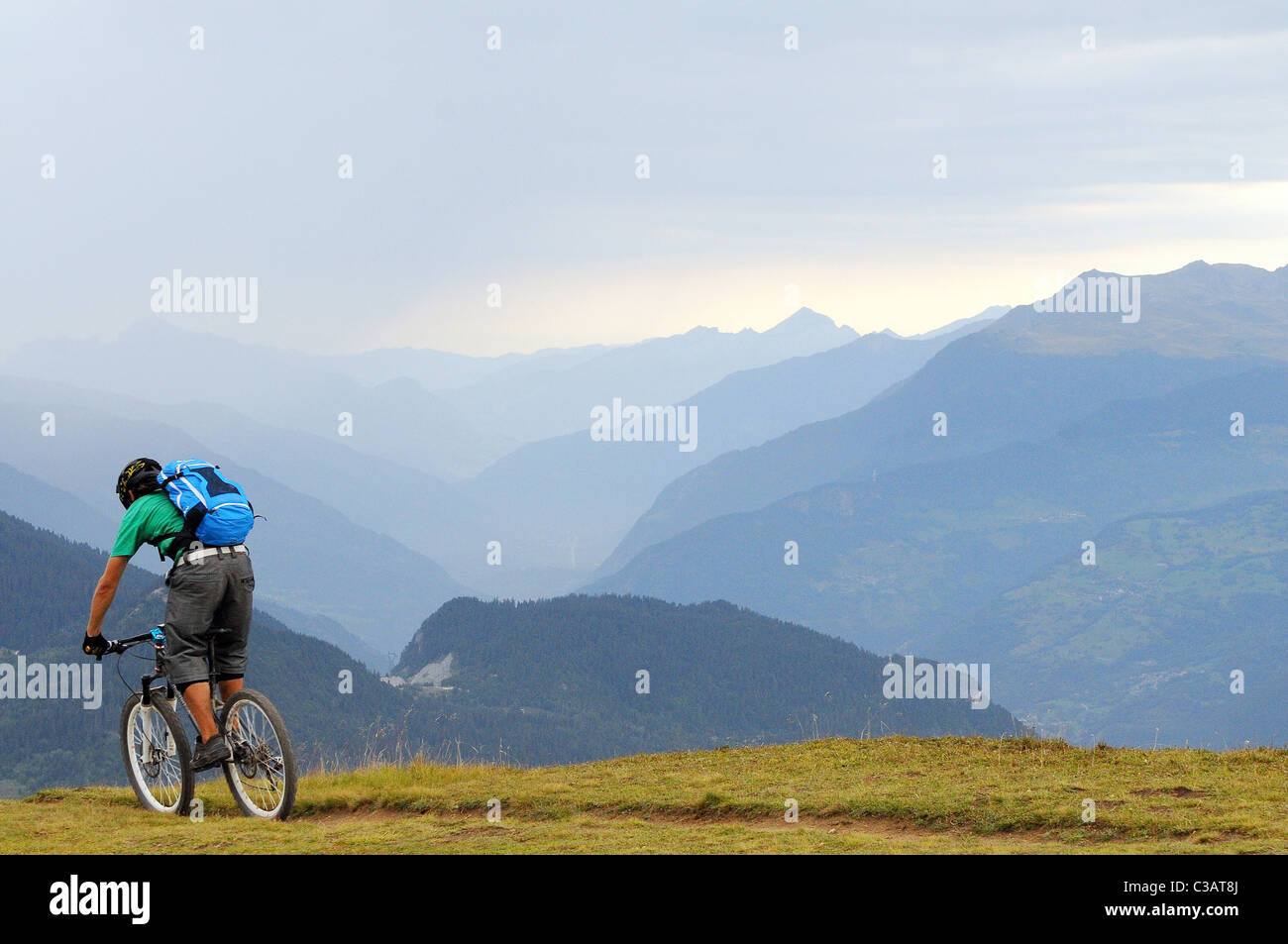 Ein Mountainbiker Gezeiten eine Spur entlang einer Kante hoch hinauf in das Skigebiet von Méribel in Frankreich. Stockfoto
