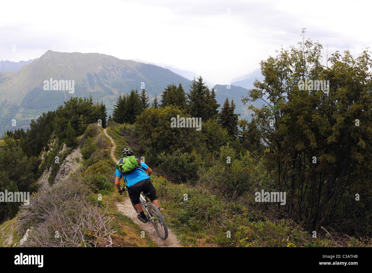 Ein Mountainbiker reitet einen Weg auf einem Bergrücken hoch oben in den Bergen in der Nähe des Skigebiets von Méribel in Frankreich. Stockfoto