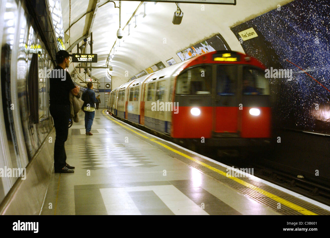 Comuters warten auf einen Zug der Piccadilly Line auf der Londoner U-Bahn. Stockfoto