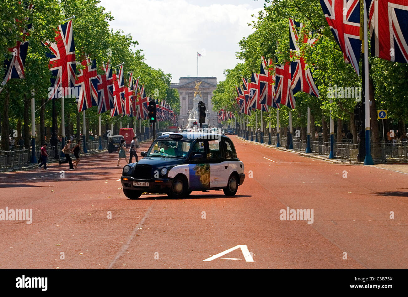 Ein Taxi mit einer Anzeige von Ubiquitous fährt entlang der Mall, London. Stockfoto