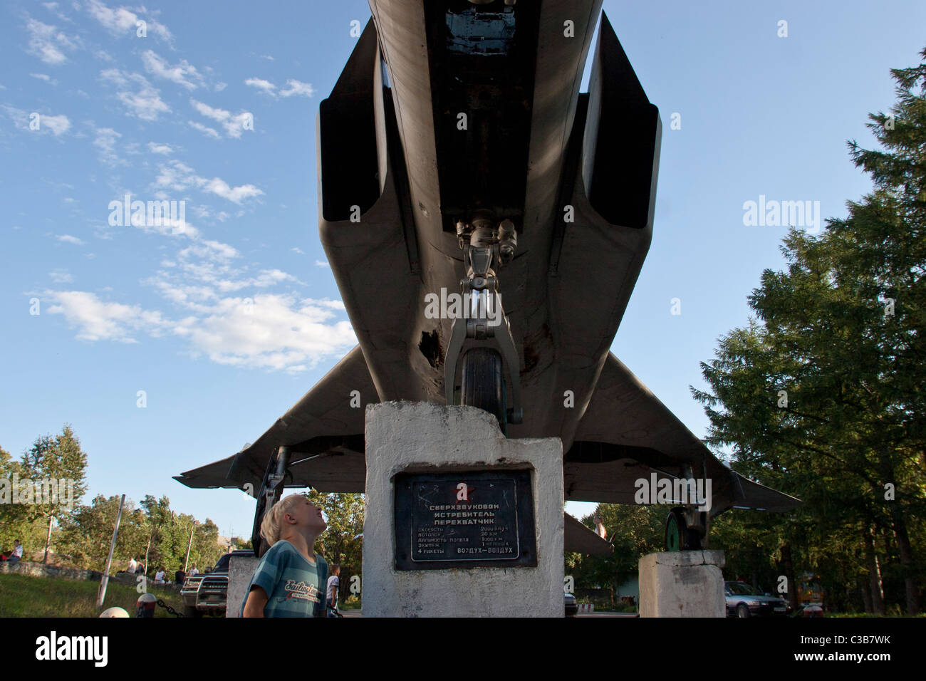 Kinder spielen in der Nähe ein Denkmal von einem Sowjet-Ära-Kampfjet in Yuzhno Sakhalinsk, Sachalin, Russland Stockfoto