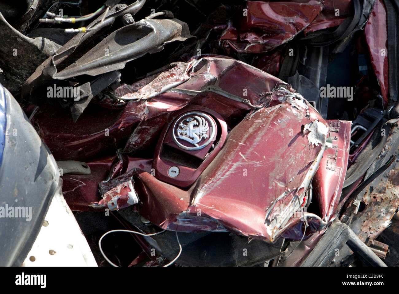 Eine Vauxhall Auto Logo ist unter einem Haufen von zerquetschten Autos sichtbar. Stockfoto