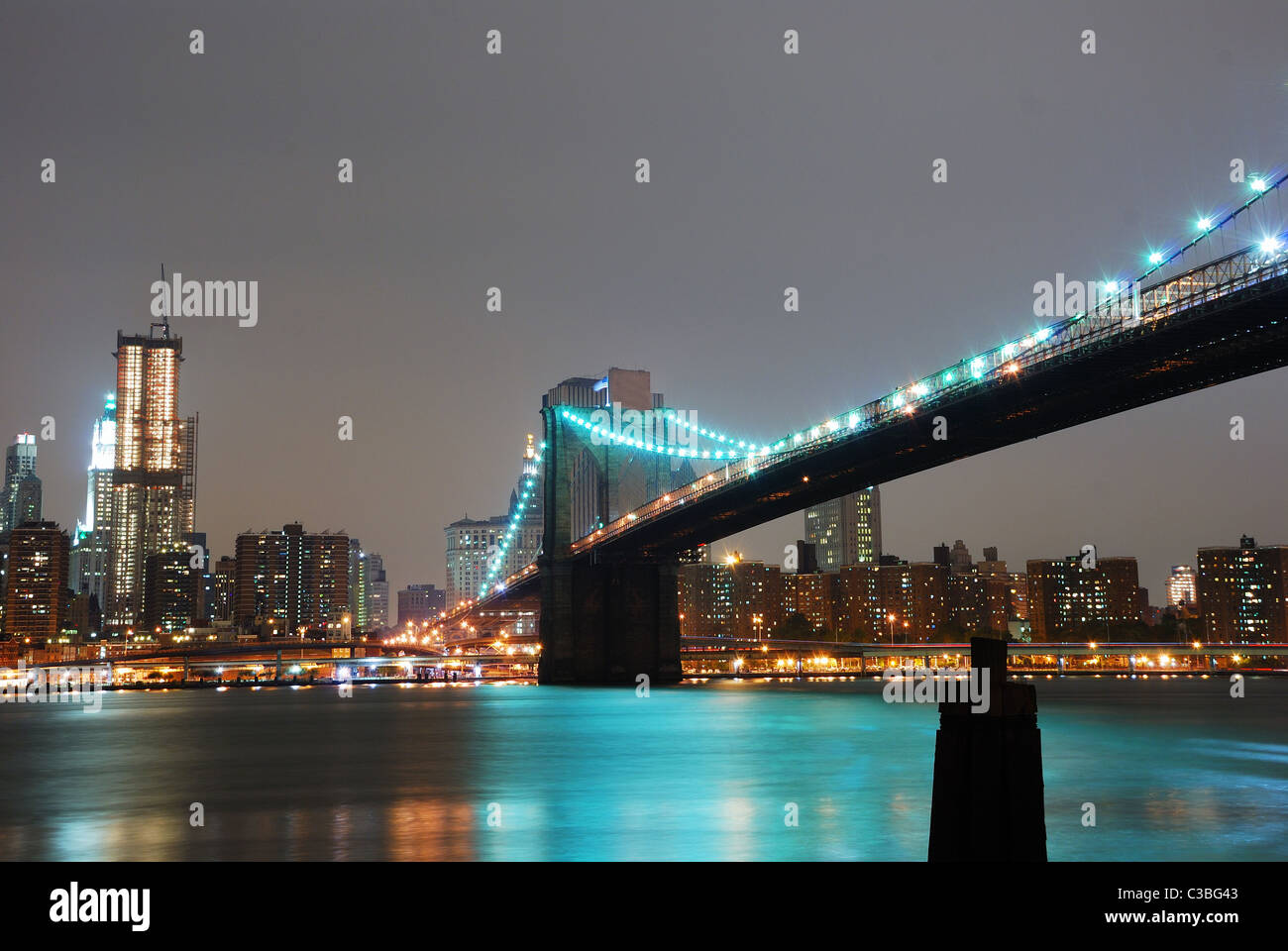 Skyline von Manhattan und Brooklyn Brücke Nachtszene über den East River, New York City Stockfoto