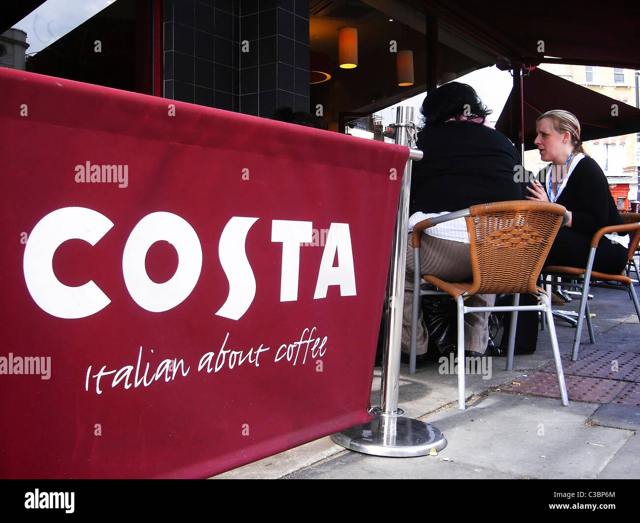 Menschen sitzen vor Costa Coffee café Stockfoto