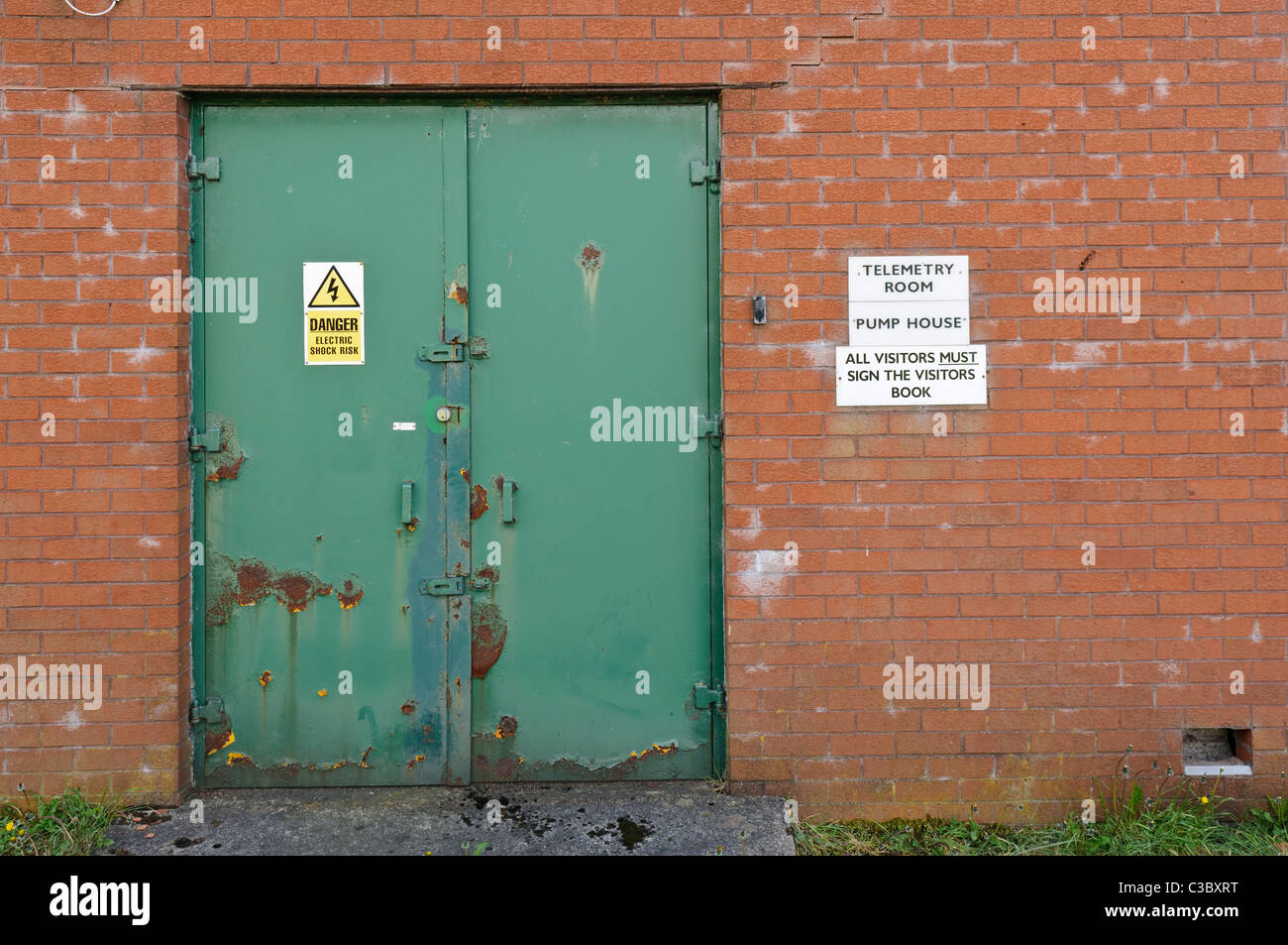 Stahltür zu einem Telemetrie-Raum an einer unbemannten Wasseraufbereitungsanlage Stockfoto