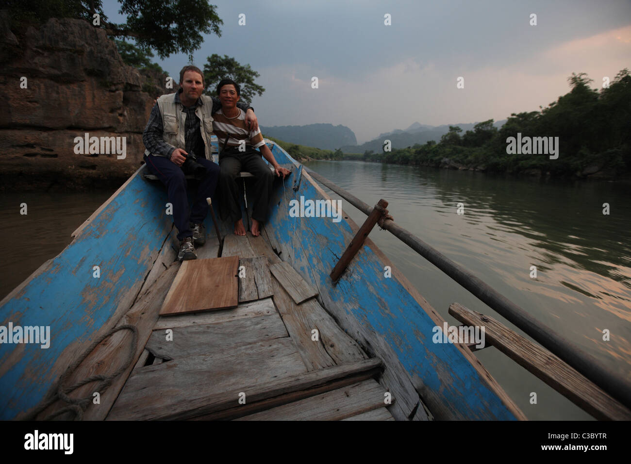 An Bord ein kleines Holzboot auf dem Fluss Sohn auf Sohn Trach, Phong Nha Ke Bang Nationalpark in Vietnam am späten Nachmittag Stockfoto