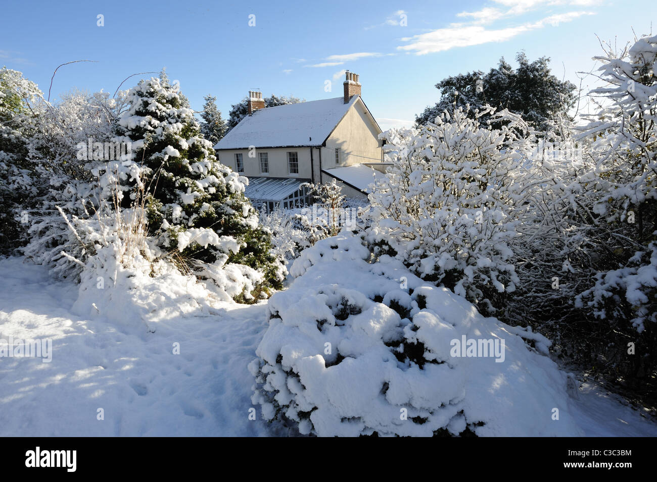 Landhaus, Wintergarten und Schnee bedeckt Garten an einem kalten Tag in East Devon Stockfoto