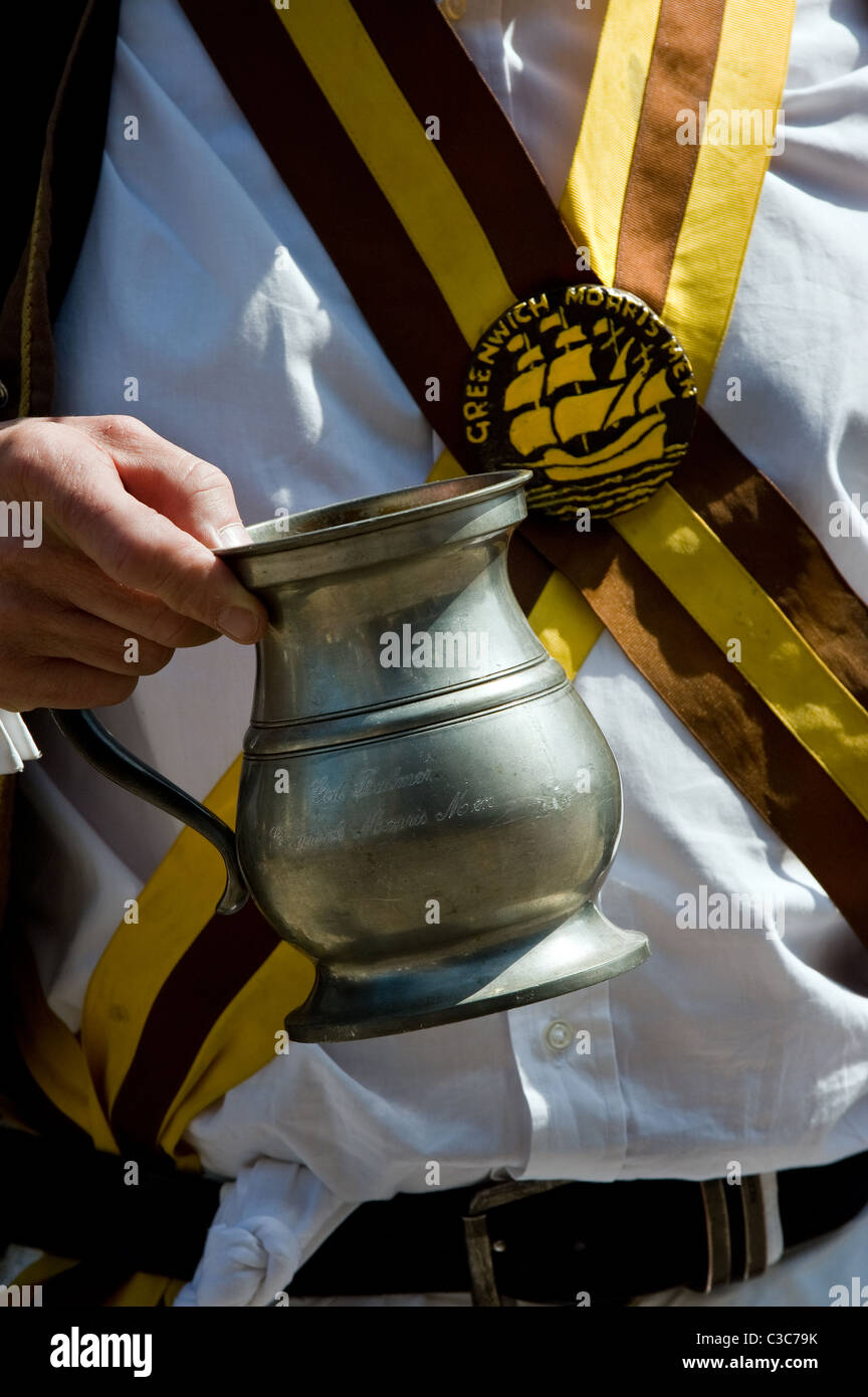 Ein Mitglied des Greenwich Morris Männer halten ein zwei Bier Krug. Stockfoto