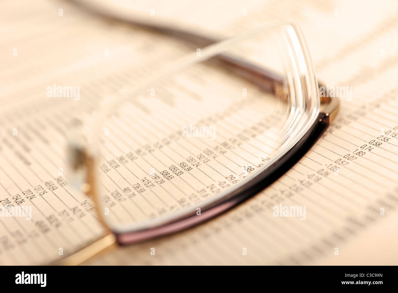 Makro von Finanzdaten durch Brillen, Handauflegen Zeitung. Stockfoto
