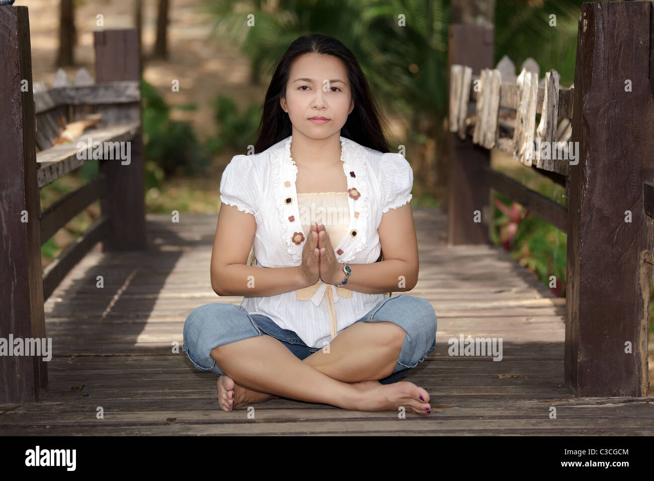 süße thai Asiatin, die Meditation über Holzbrücke Stockfoto
