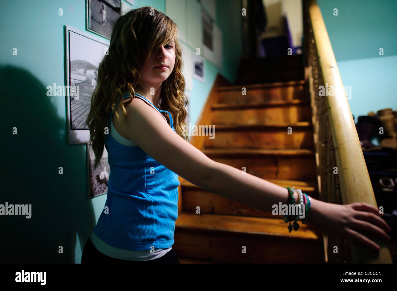 ein zwölf Jahre alter Teenager-Mädchen stehend auf der Treppe zu Hause UK Stockfoto