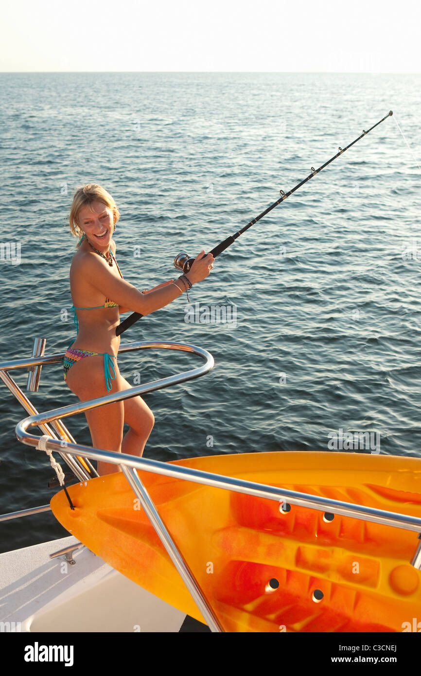 junge Frau mit Angelrute auf yacht Stockfoto