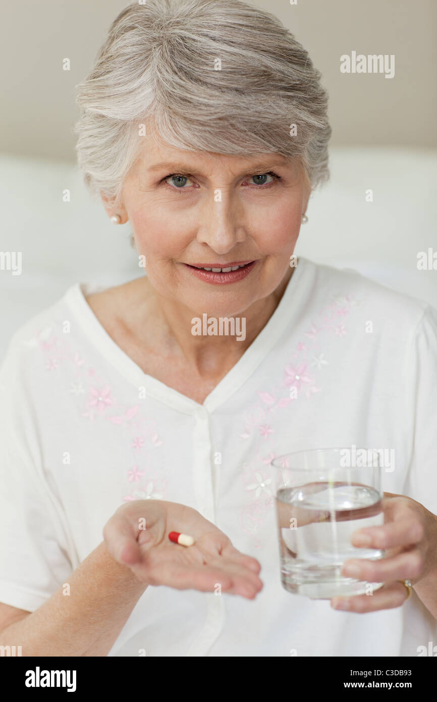 Ältere Frau mit Pillen in der Hand Stockfoto
