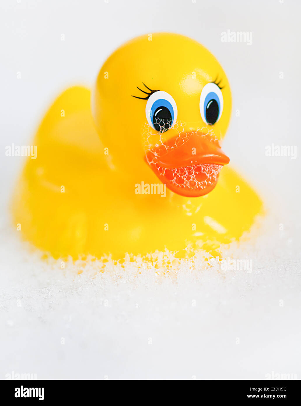 Badezeit Spaß mit einer gelben Gummiente schweben in einer Badewanne voller Wasser und Seife Luftblasen. Stockfoto
