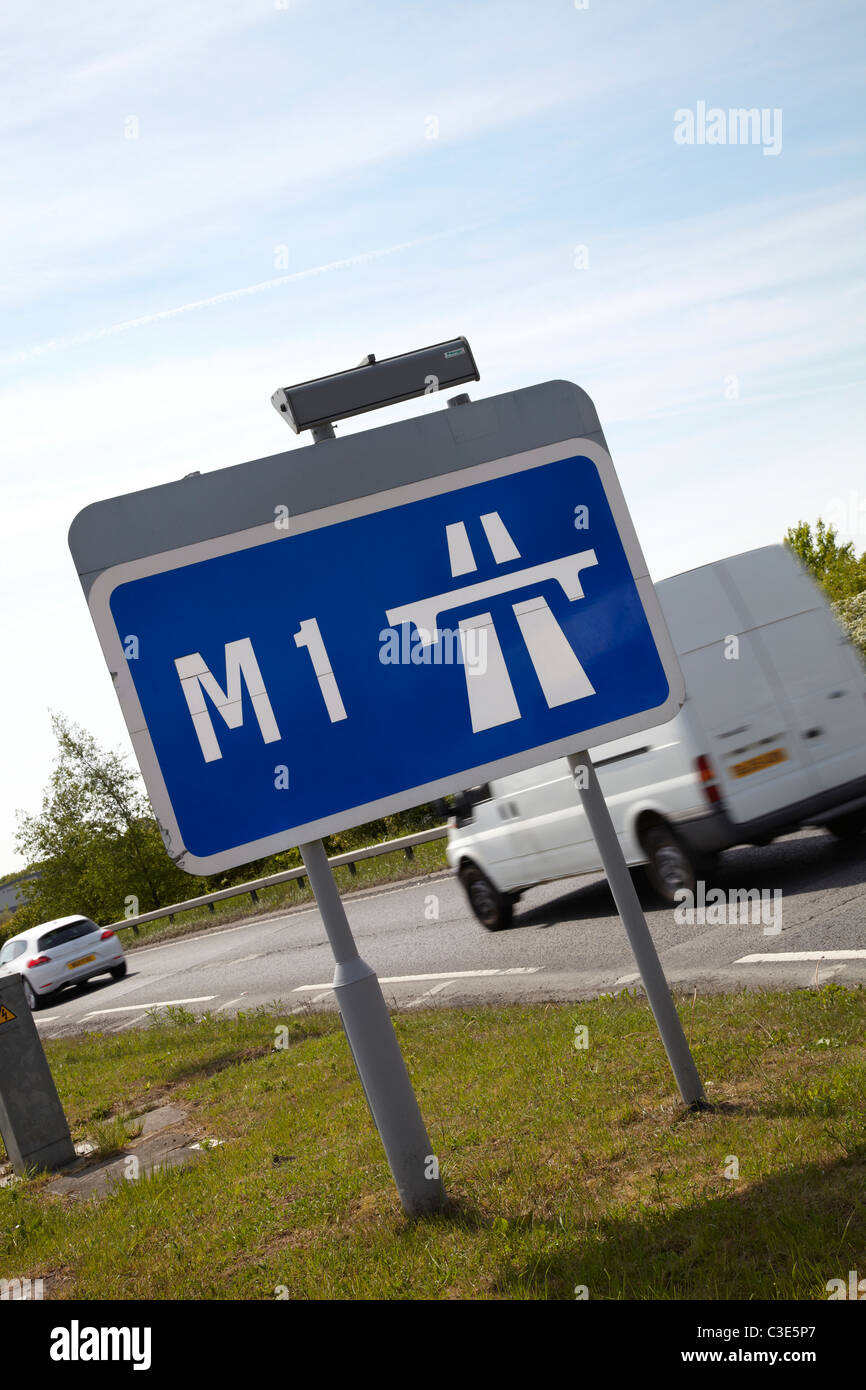 Autobahn M1 England Sign. Sonniger Tag mit blauem Himmel. Weißer Lieferwagen und Auto fahren im Hintergrund. Stockfoto