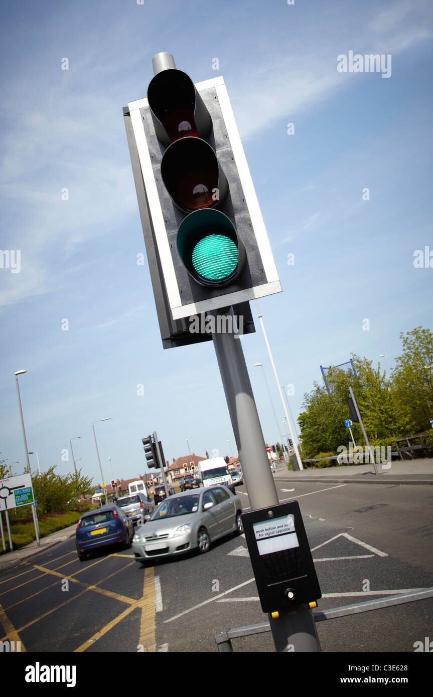 Fußgängerüberweg-Taste drücken, um die Ampel zu stoppen zu aktivieren. Verkehrsinsel zeigt in Ferne. Sonniger Tag. Grünes Licht Stockfoto