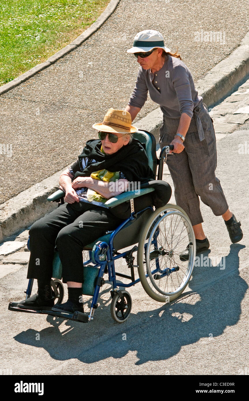 Frau drängen ältere Frau im Rollstuhl - Frankreich. Stockfoto