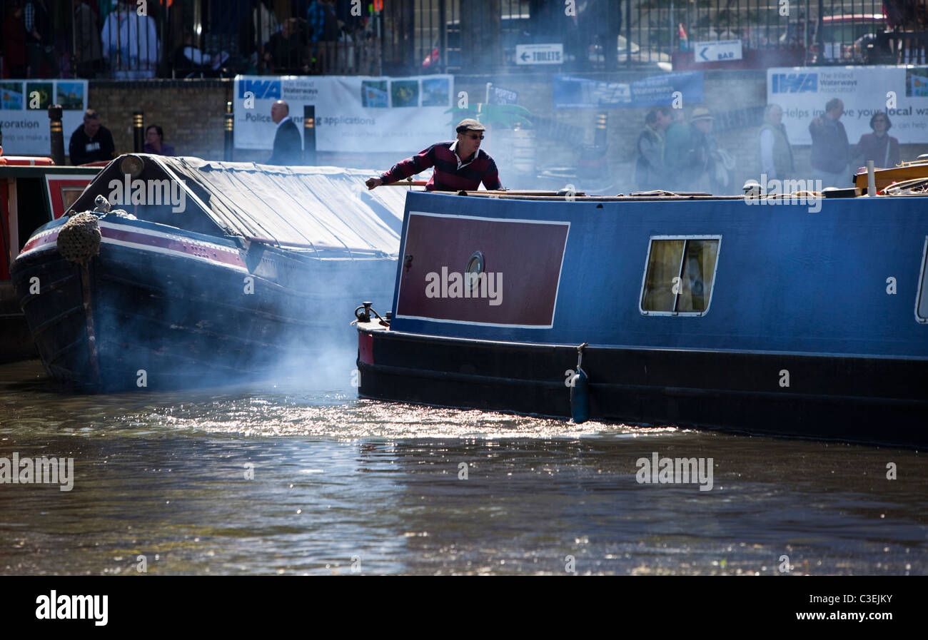 Narrowboat Steuermann tätig sein Schiff am Regents Kanal bei Klein-Venedig, London, England, UK. Stockfoto