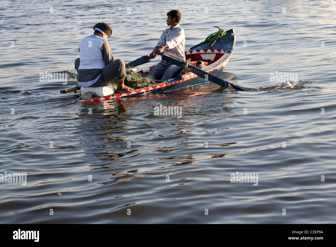 Ein kleinen hölzernen Fischerboot Arm an Wasser mit Mann Angeln und Rudern jungen umgeben leicht gebrochen, Nil, Ägypten, Afrika Stockfoto