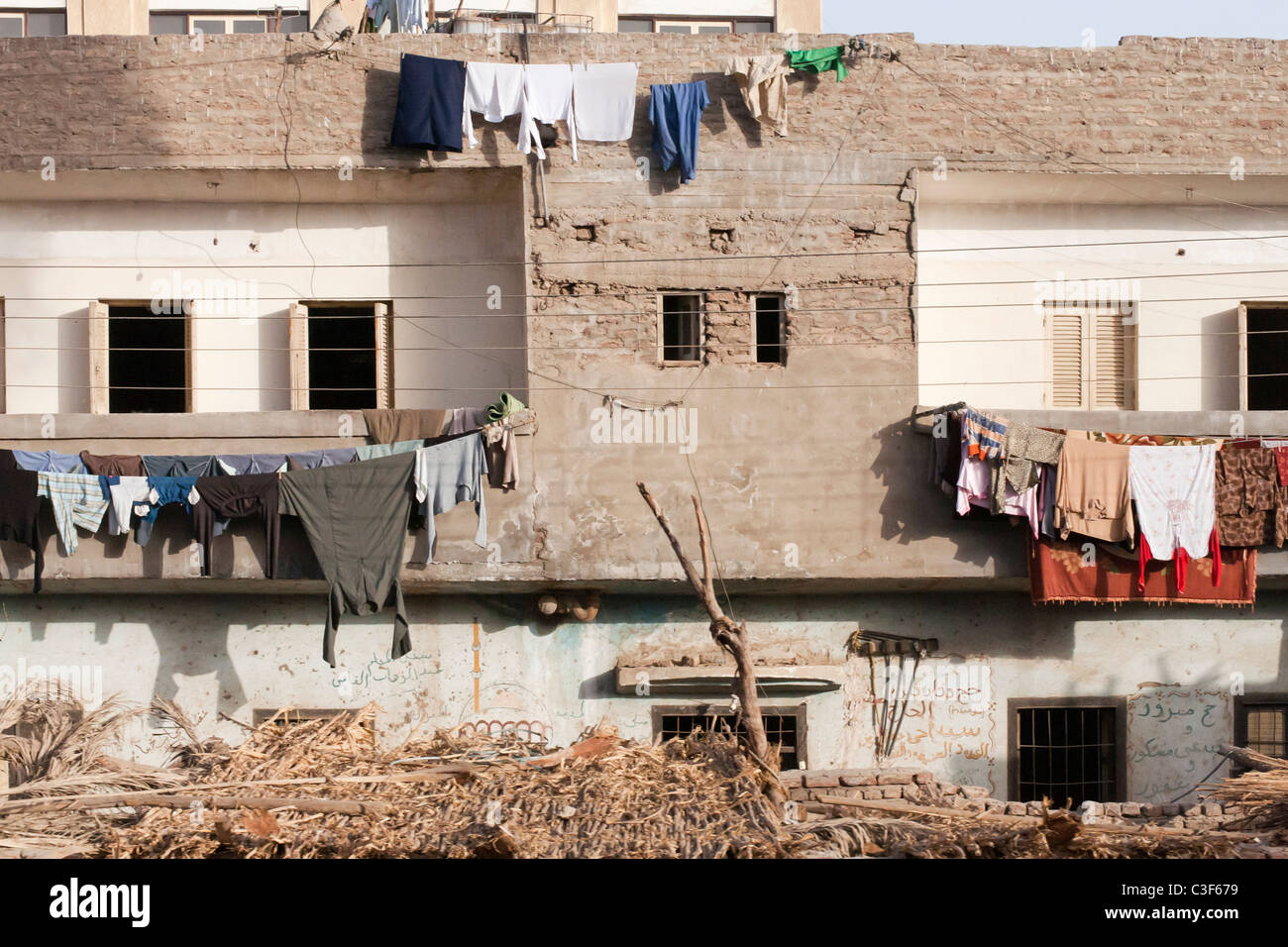 Traditionellen Lehmziegel Reihenhaus-Apartments mit waschen hängen von Wänden und Balkonen, Ägypten, Afrika Stockfoto