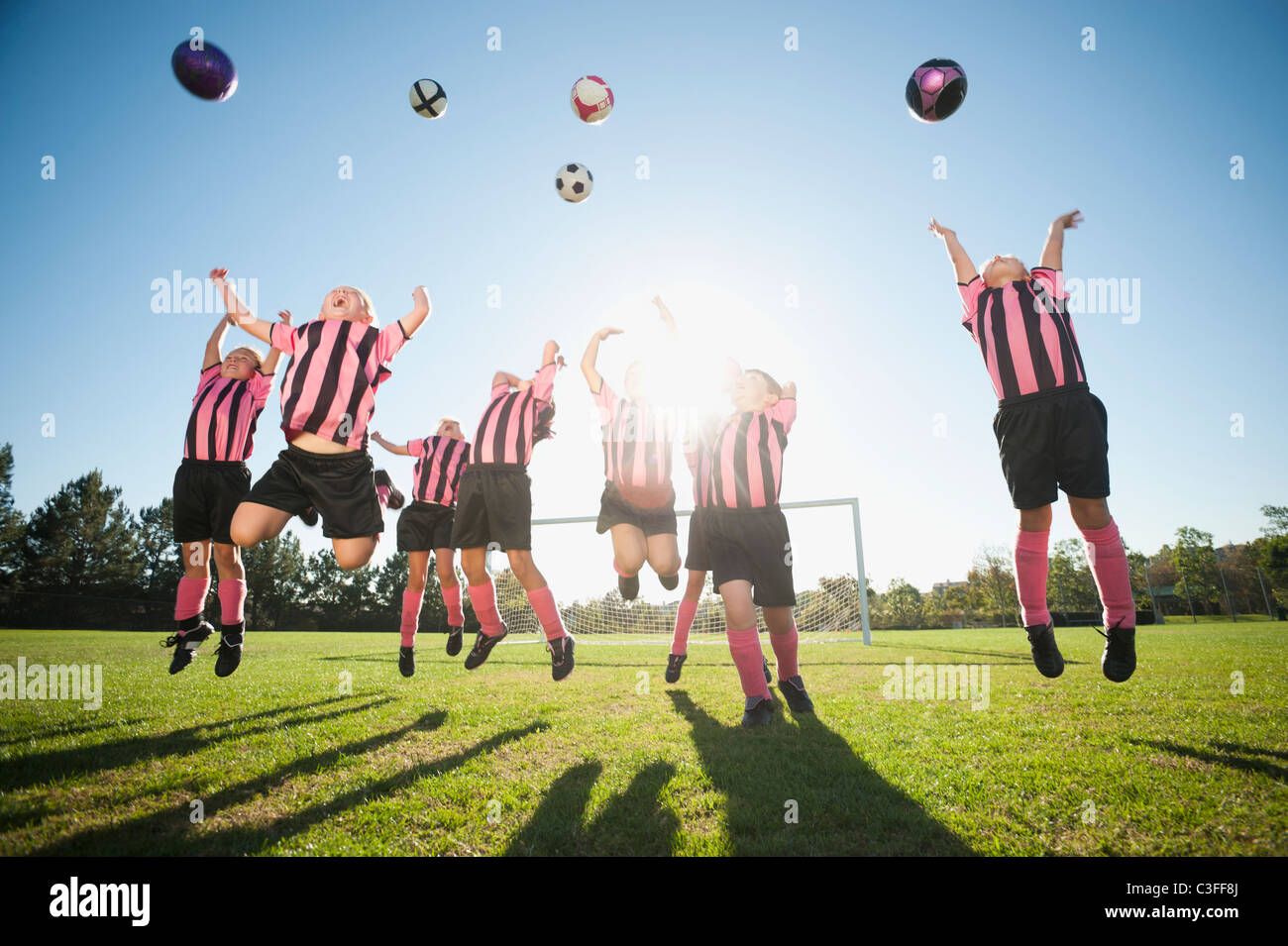 Mädchen-Fußball-Spieler üben mit Fußbällen Stockfoto