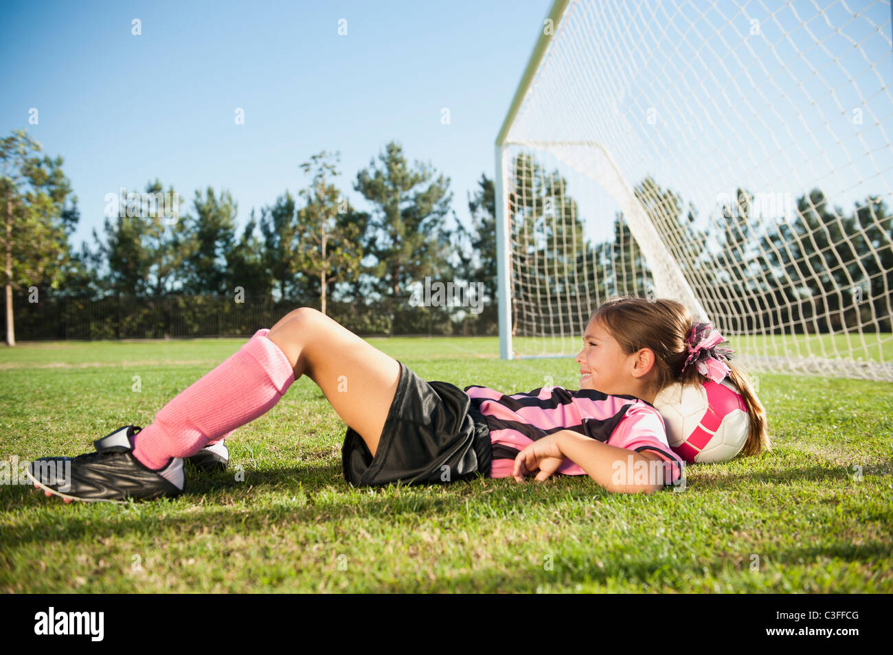 Verlegung mit Kopf auf Fußball hispanischen Mädchen-Fußball-Spieler Stockfoto