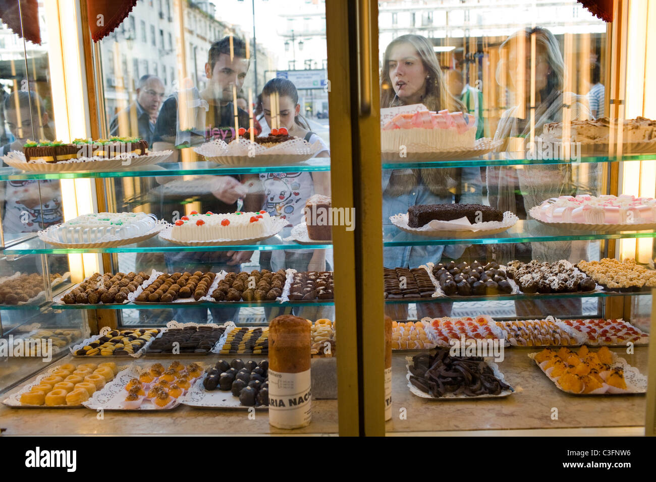 Frauen untersuchen Dessert Anzeige im Fenster der Confeitaria Nacional, Baixa, Lissabon, Portugal Stockfoto