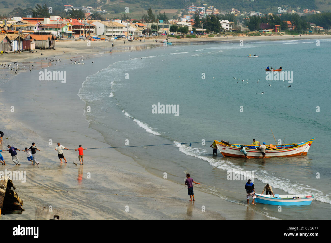 Draufsicht der lokalen Fischer ziehen ihre Angelboote/Fischerboote am Strand von Garopaba, Bundesstaat Santa Catarina, Süd-Brasilien Stockfoto