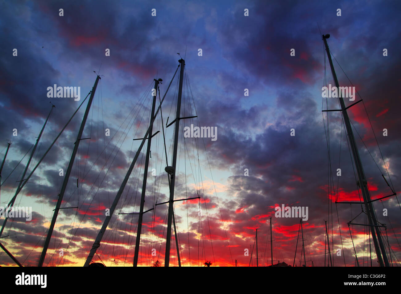 dramatische Marina Segelboot Mast Sonnenuntergang Himmel Hintergrundbeleuchtung skyscape Stockfoto